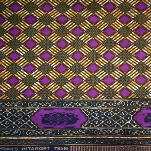 Textile with intricate purple and gold pattern on a black background