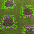 Patterned fabric with green and purple design on a green background