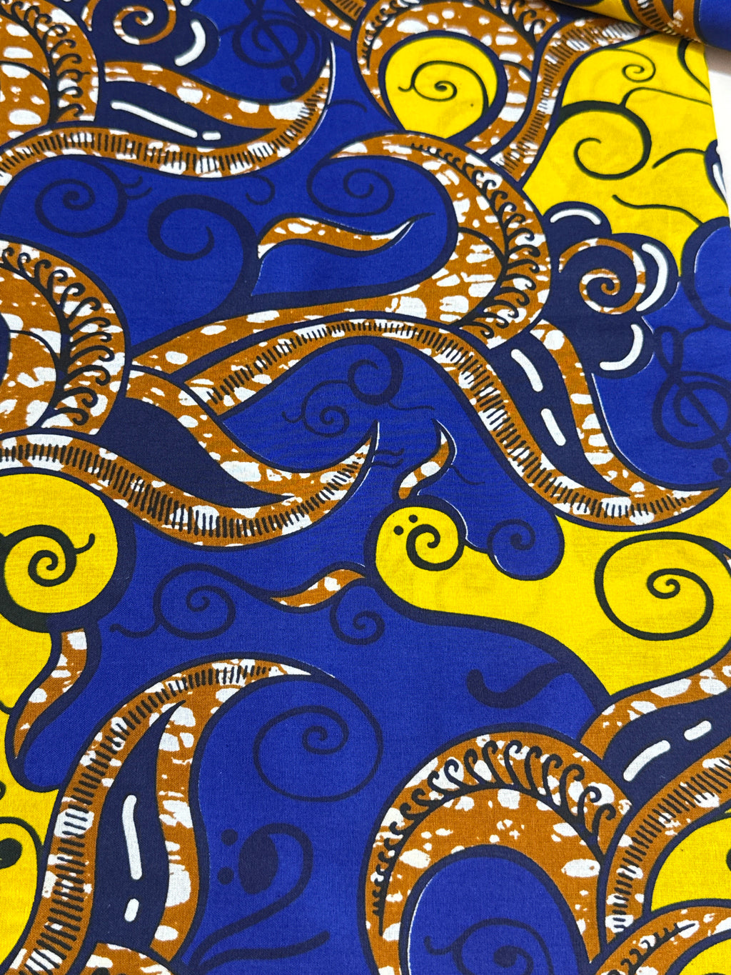 Close-up of a vibrant fabric pattern with blue, yellow, and brown colors.