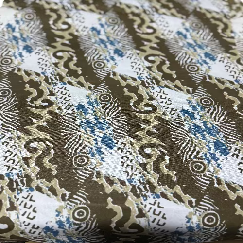 Close-up of a fabric with intricate patterns in brown, blue, and white.