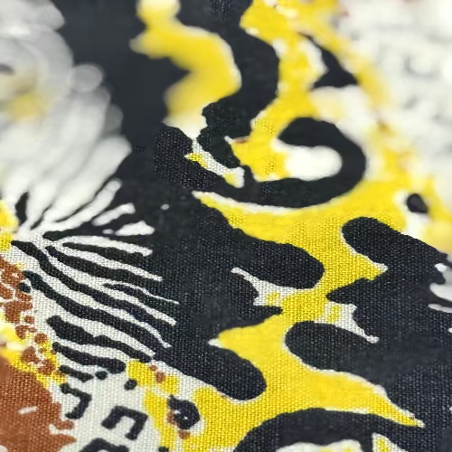Close-up of fabric with black and white abstract patterns on a yellow background