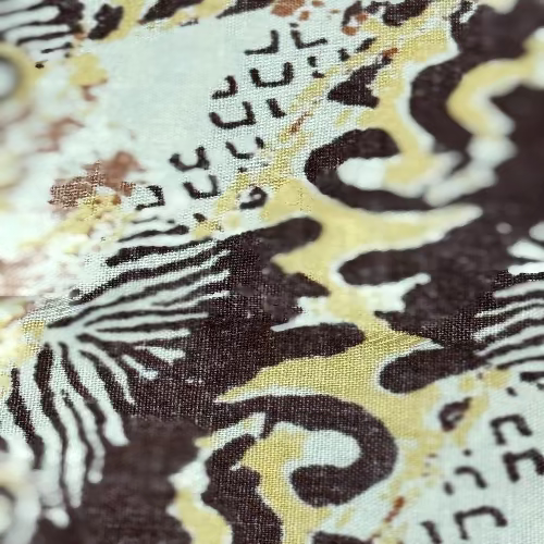 Close-up of a fabric with a black and white pattern on a yellow background