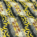 Close-up of a fabric with intricate black, yellow, and brown pattern