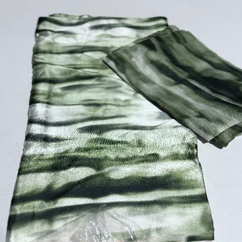 Green and white striped fabric on a light gray background