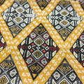 Close-up of a fabric with a geometric pattern featuring yellow, black, and white colors.