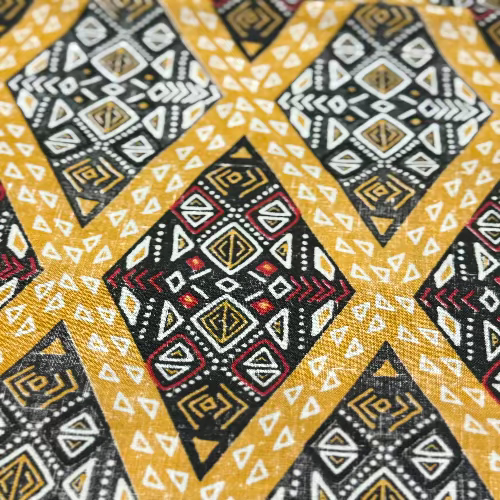 Close-up of a fabric with a geometric pattern featuring yellow, black, and white colors.