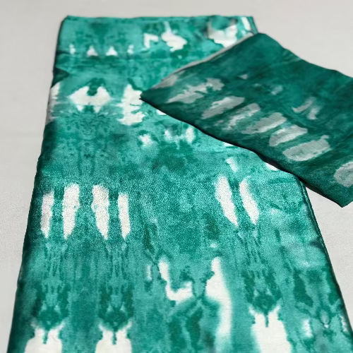 Teal and white tie-dye fabric on a light gray background