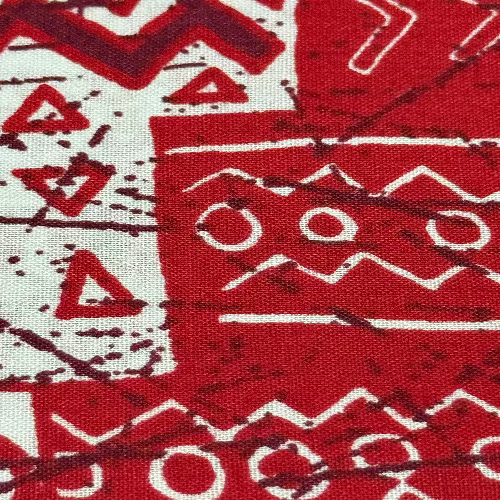 Close-up of a red and white patterned fabric with geometric shapes.