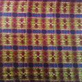 Colorful fabric with a pattern of people and flowers on a green background