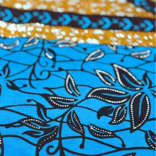 Close-up of a fabric with blue floral pattern and colorful border