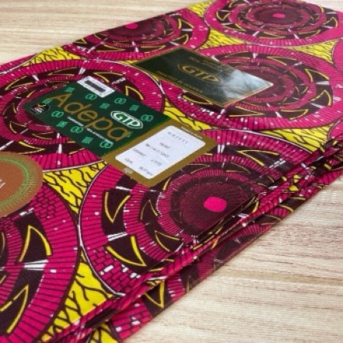 Colorful fabric with patterns and labels on a wooden surface