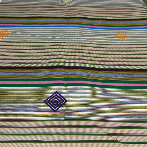 Striped shirt with colorful patterns and logos on a plain background