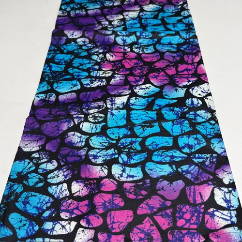 Colorful tie-dye fabric with blue, purple, and pink patterns on a white background
