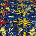 Colorful fabric with abstract patterns in blue, yellow, and red on a dark background