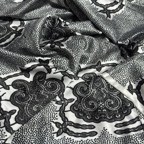 Black paisley pattern on white fabric