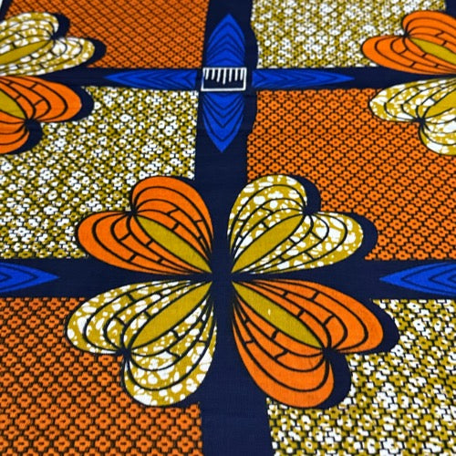 Colorful fabric pattern with orange and yellow butterflies on a blue and orange background